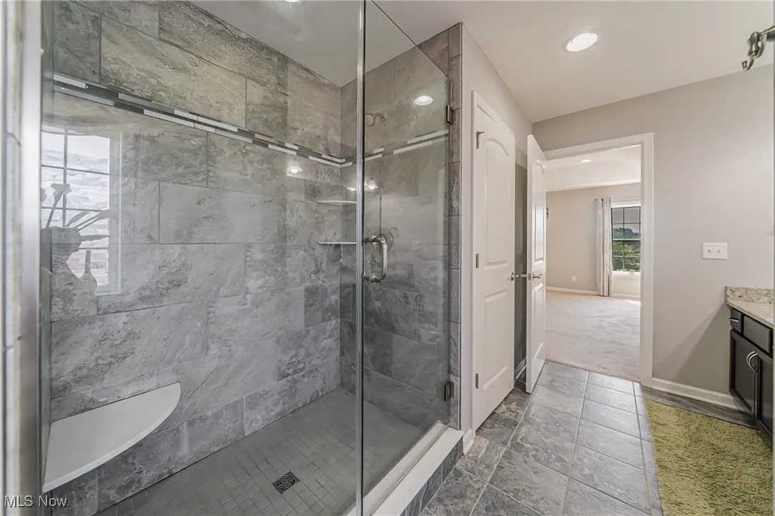 Full bathroom with a stall shower, vanity, and recessed lighting
