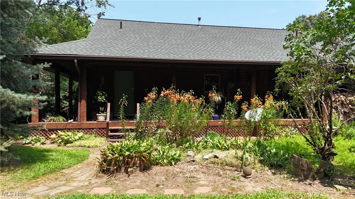 Rear view of property with roof with shingles and a porch