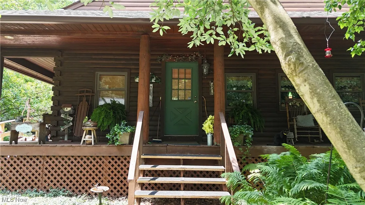 Property entrance featuring log exterior and covered porch