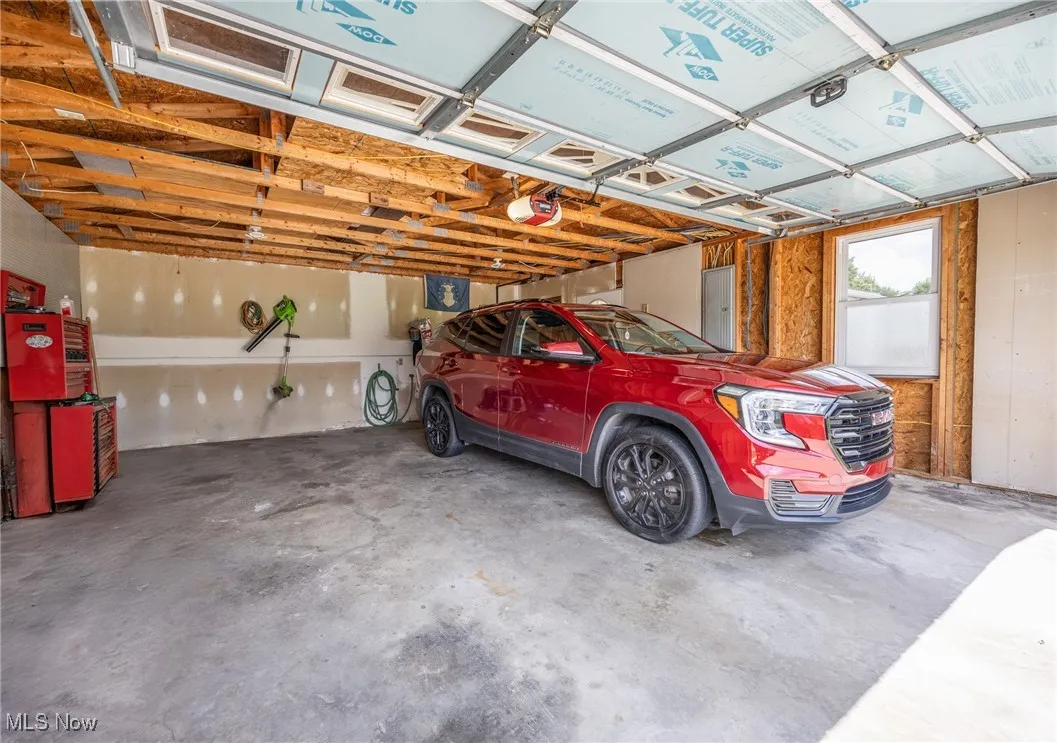 Garage featuring electric panel and a garage door opener