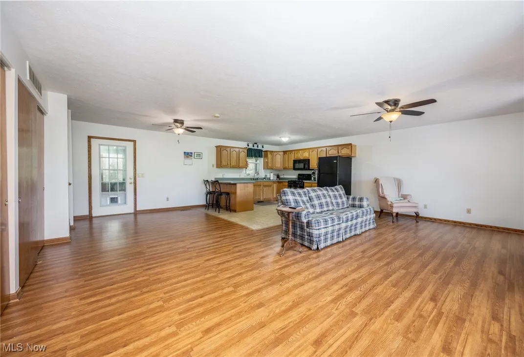 Living area with ceiling fan and light wood finished floors