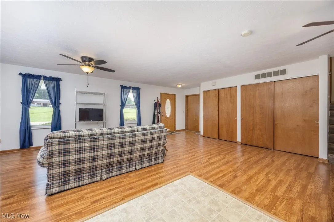 Living room with ceiling fan and light wood-style flooring