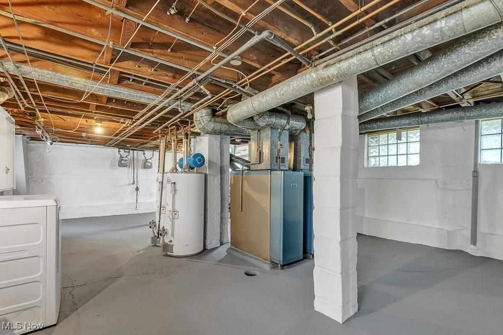 Below grade area featuring washer / clothes dryer, water heater, and heating unit