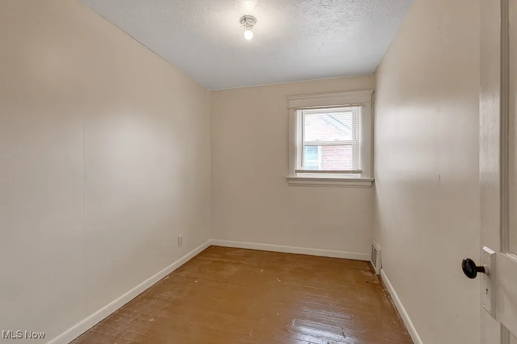 Unfurnished room with light wood-type flooring and a textured ceiling