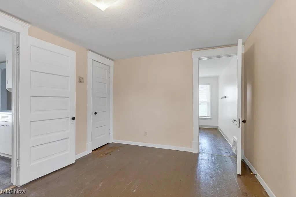 Spare room featuring wood finished floors and a textured ceiling