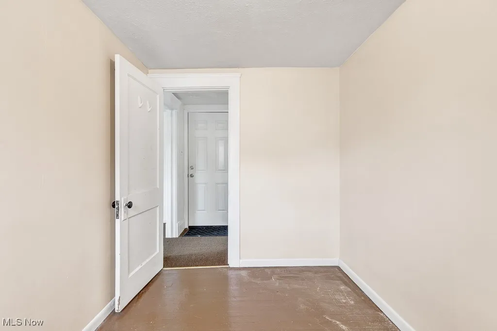 Unfurnished room with a textured ceiling and wood finished floors