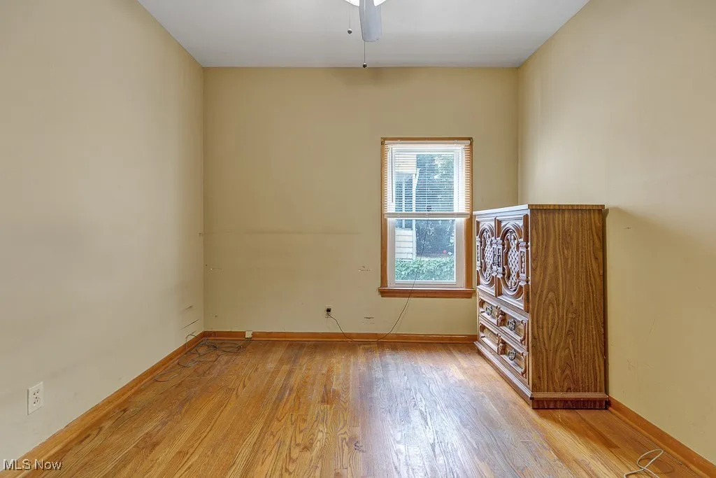 Spare room with wood finished floors and a ceiling fan