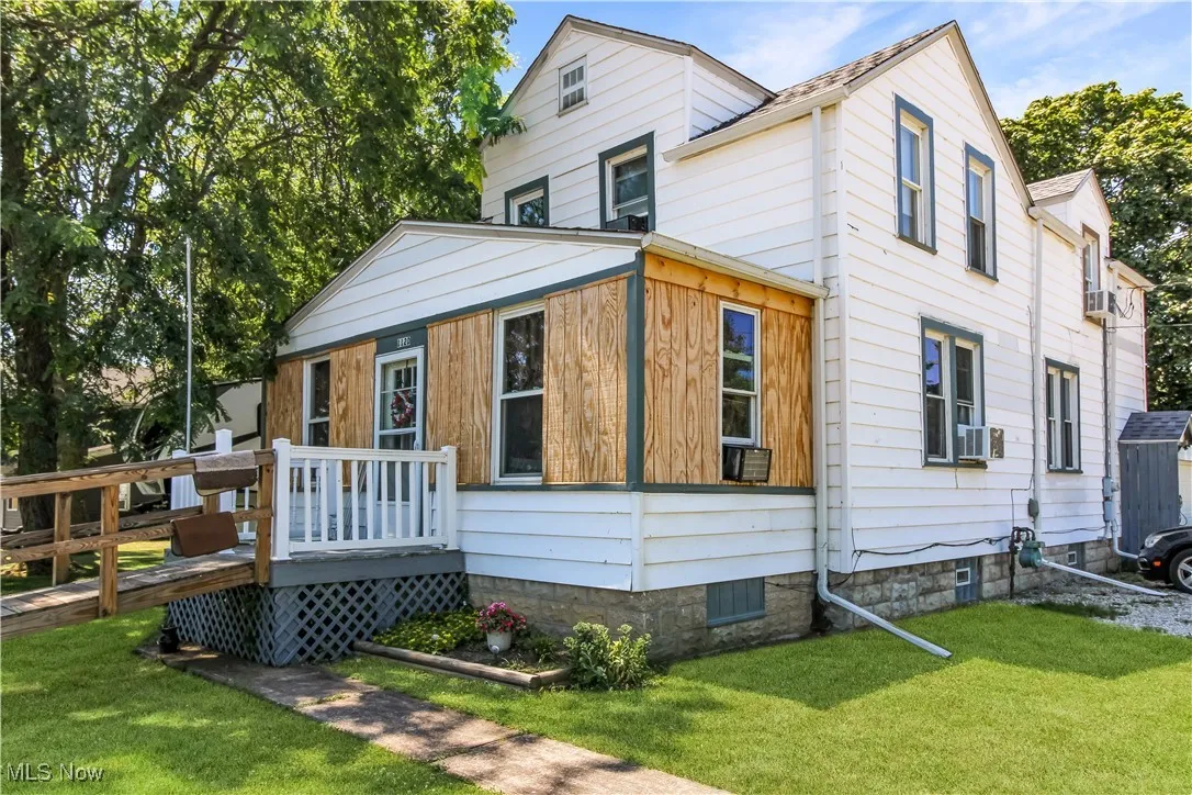View of front facade with a deck and a front yard