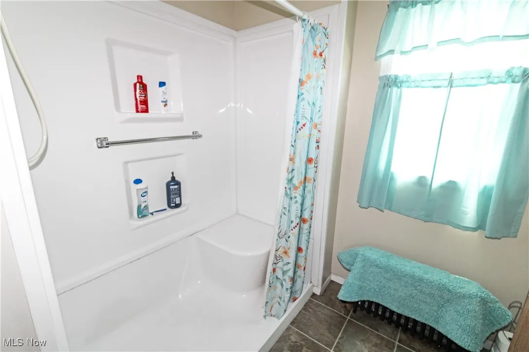 Full bath featuring tile patterned floors and a shower with curtain