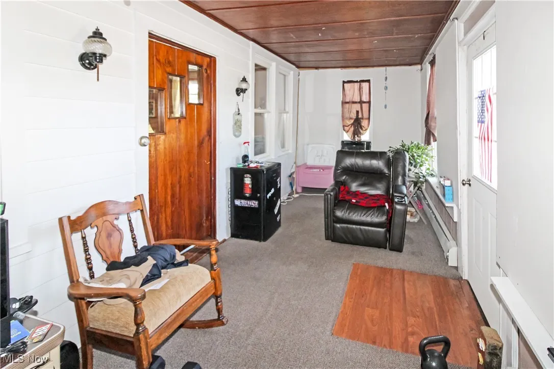 Sitting room featuring wooden ceiling, carpet floors, and a baseboard radiator
