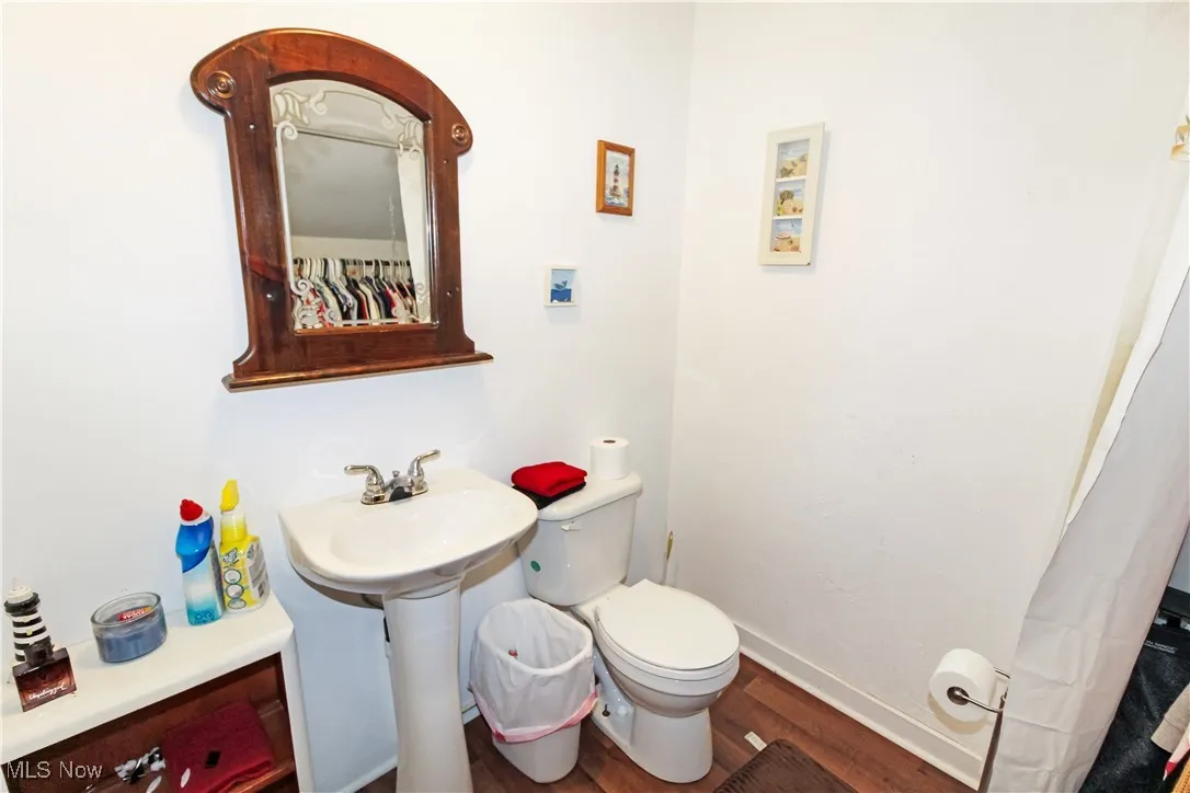 Full bathroom featuring wood finished floors and toilet