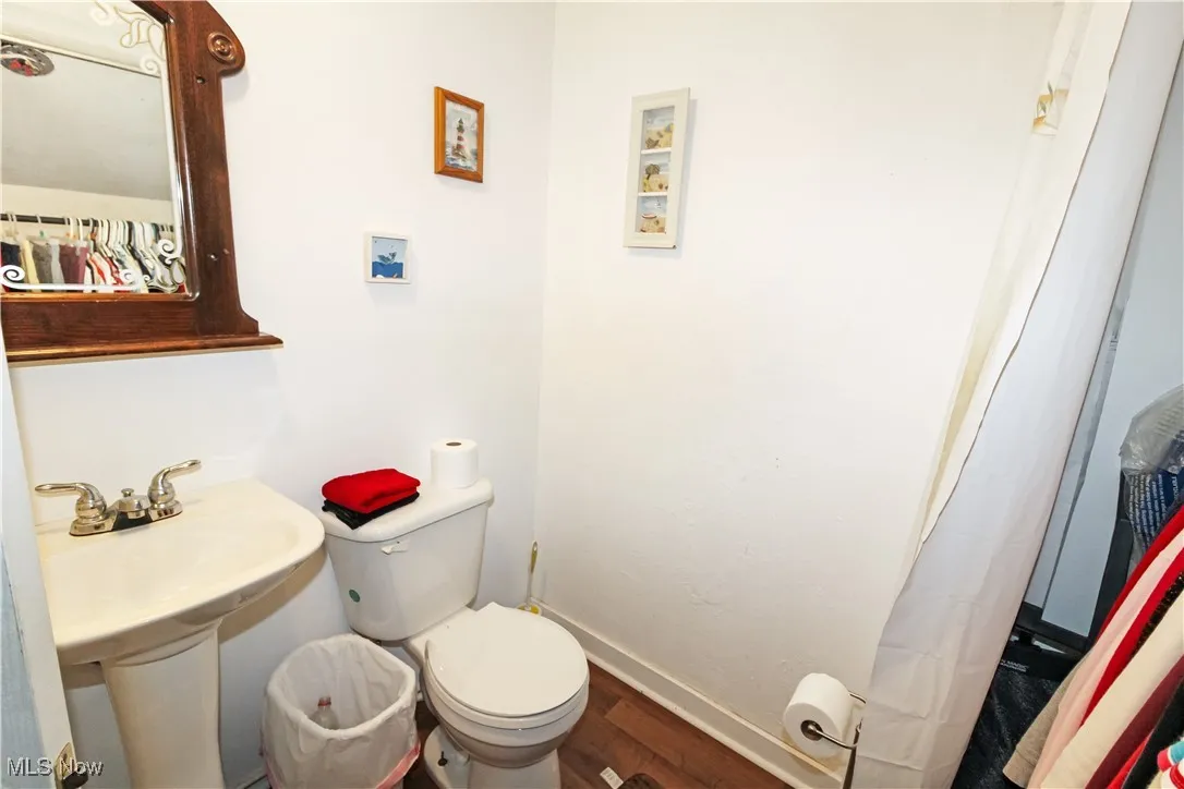 Full bathroom with wood finished floors and toilet