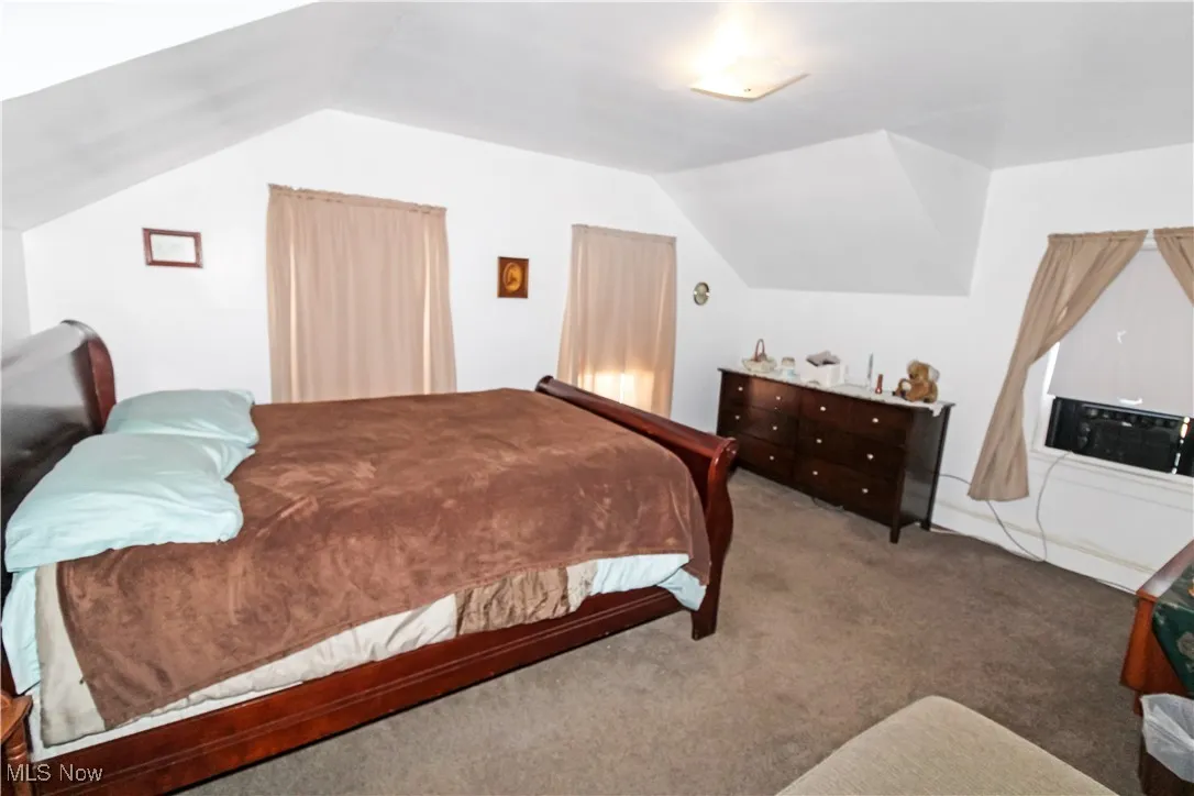 Bedroom featuring vaulted ceiling and carpet