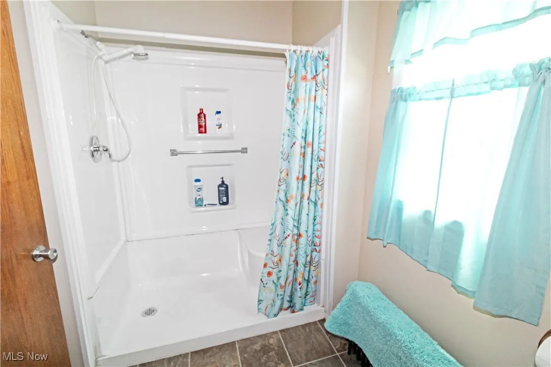 Bathroom with a shower with shower curtain