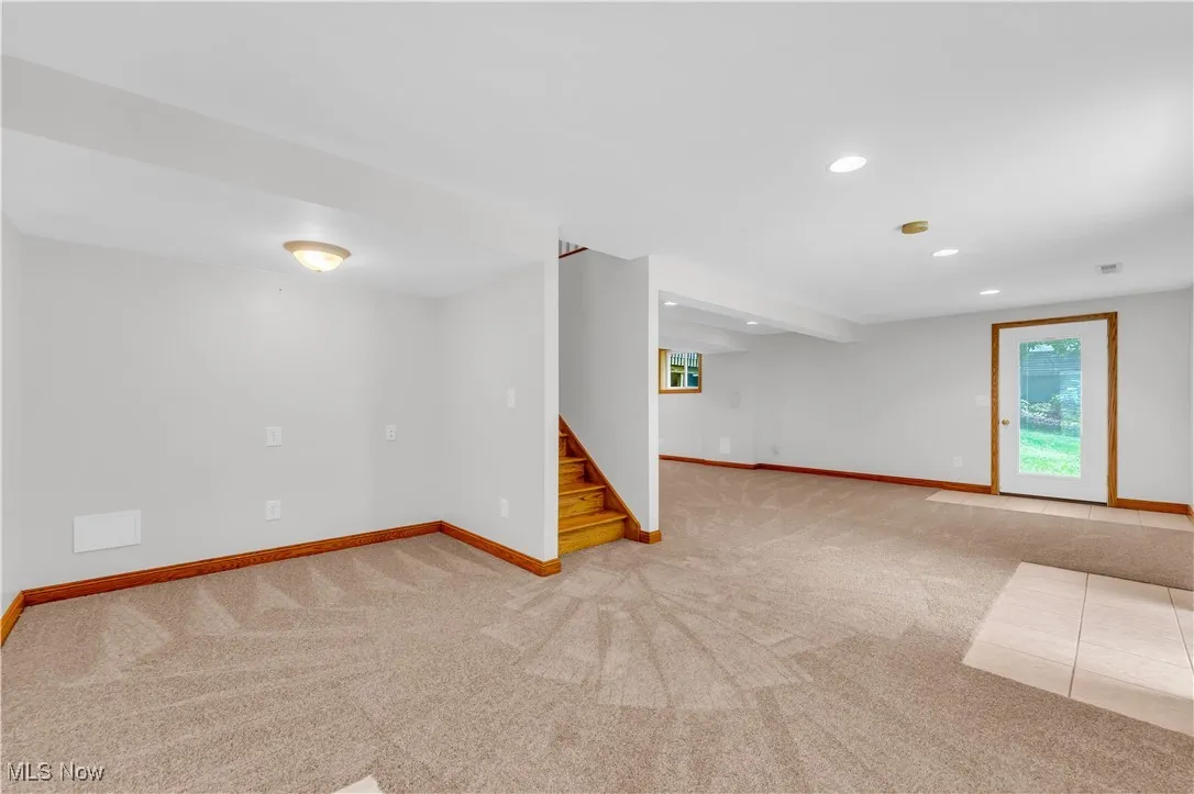 Basement with carpet flooring, stairway, and recessed lighting