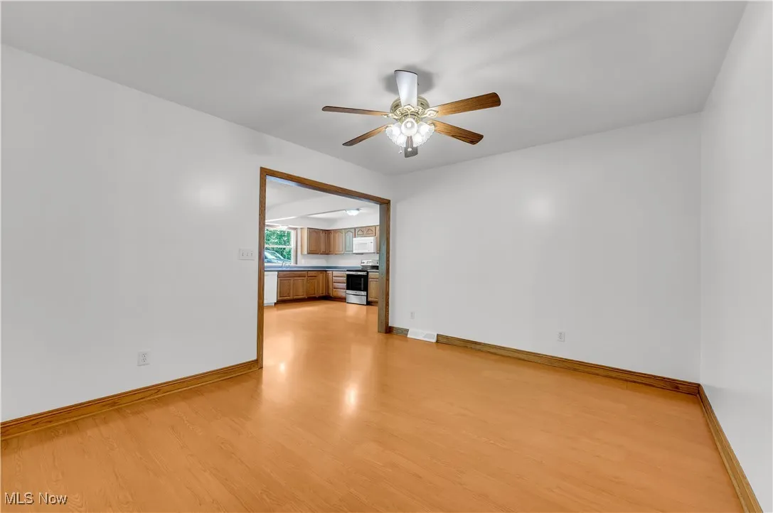 Unfurnished living room featuring light wood-style flooring and a ceiling fan