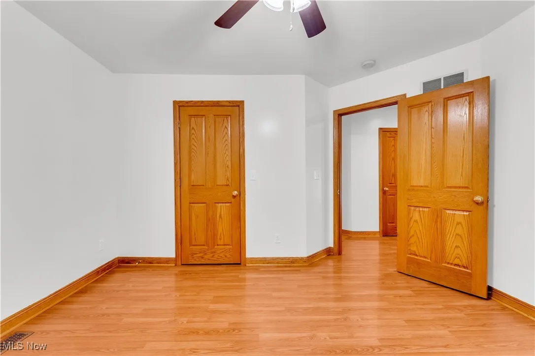Unfurnished room with a ceiling fan and light wood finished floors