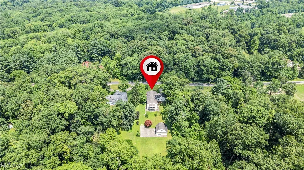 Aerial view of property's location with a heavily wooded area