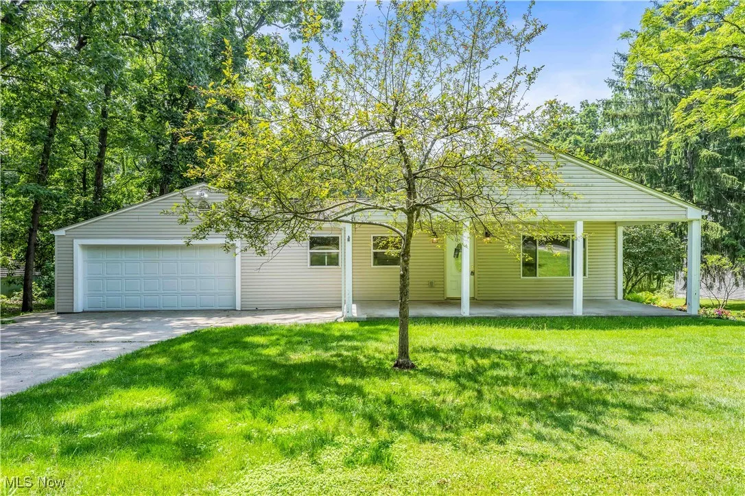 View of front of home featuring a front lawn, a garage, and concrete driveway