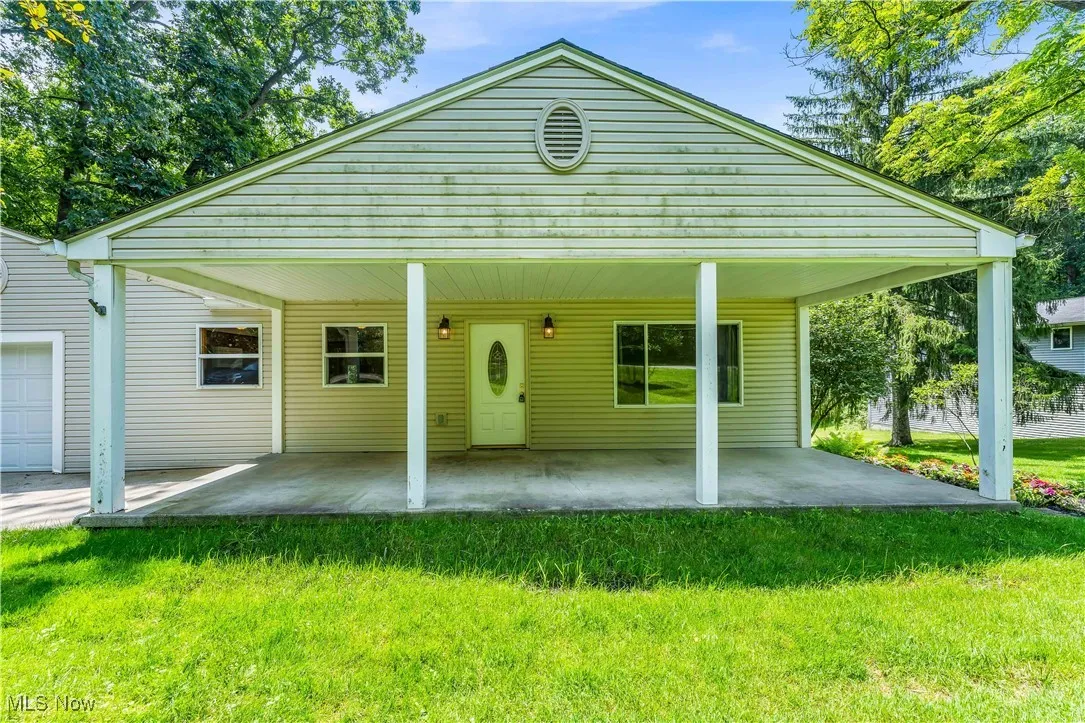 View of front of home with a front yard and a patio