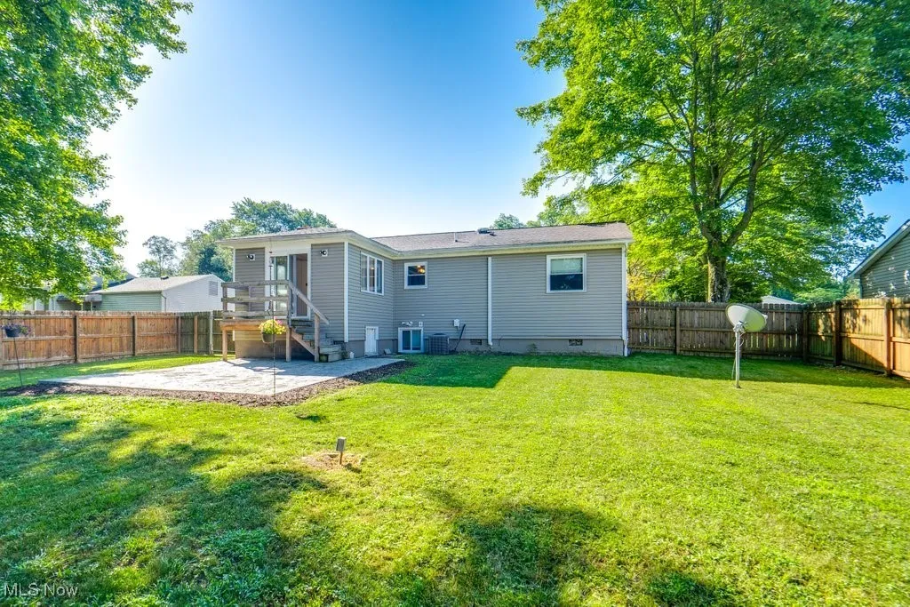 Rear view of house with a patio area and a fenced backyard