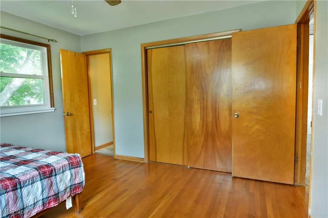 Bedroom with wood finished floors and a closet