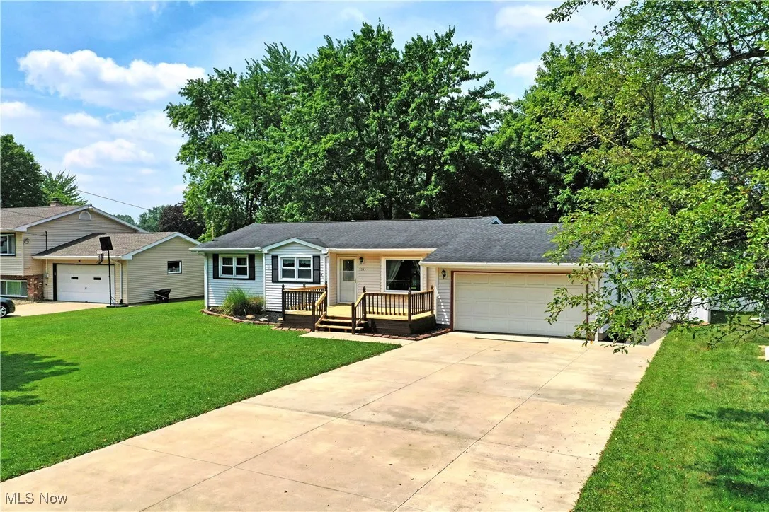 View of front of home featuring an attached garage, a front lawn, and concrete driveway