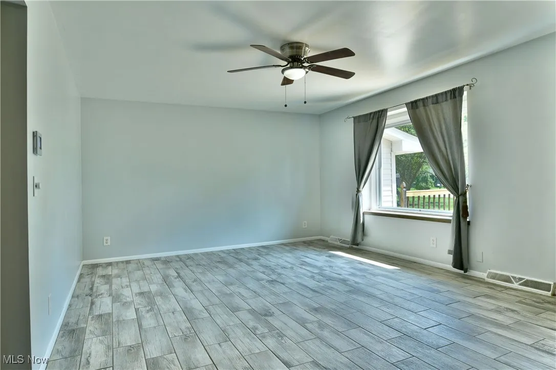 Unfurnished room with ceiling fan and wood finished floors