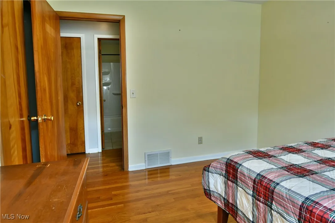 Bedroom featuring wood finished floors and baseboards