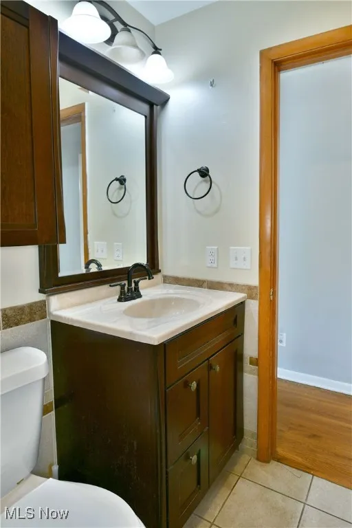 Half bathroom featuring vanity and tile patterned floors