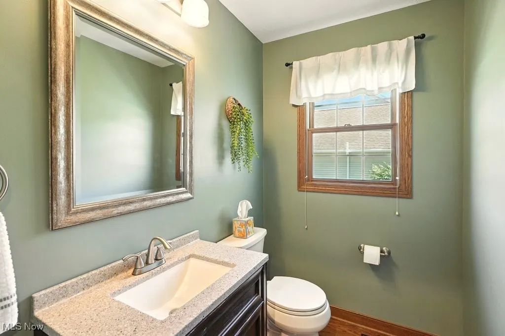 Half bath with vanity and wood finished floors