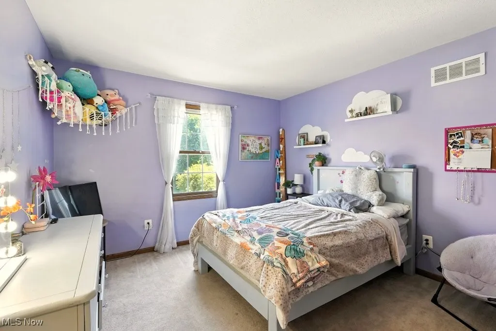 Bedroom with light colored carpet and baseboards