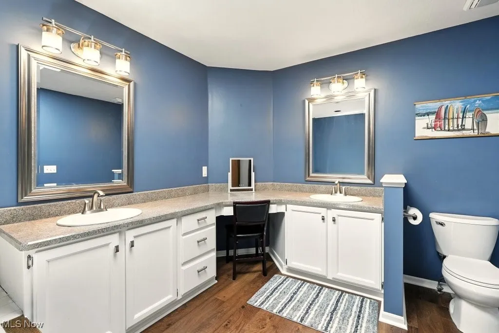 Full bath featuring double vanity and wood finished floors