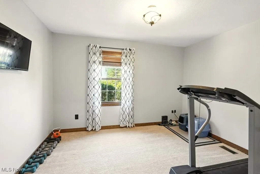 Workout room with carpet flooring and baseboards