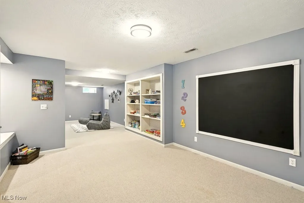 Living area with carpet and a textured ceiling