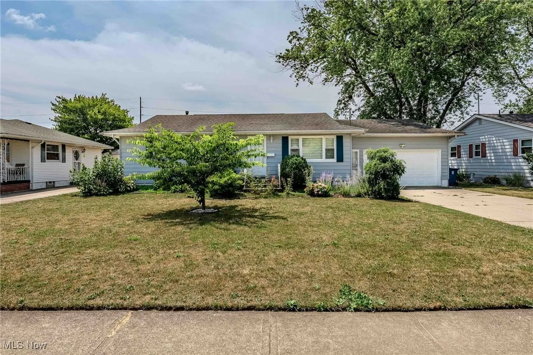 Single story home featuring concrete driveway, a front yard, and a garage
