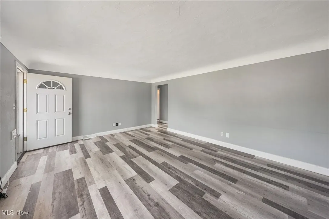 Spare room featuring wood finished floors and baseboards