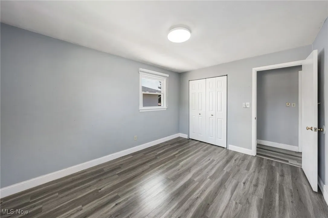 Unfurnished bedroom with dark wood-type flooring and a closet
