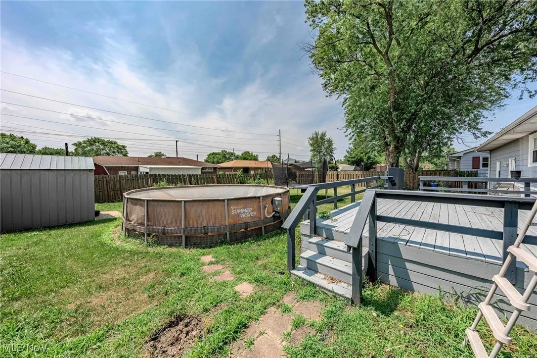 Fenced backyard with a deck and a shed