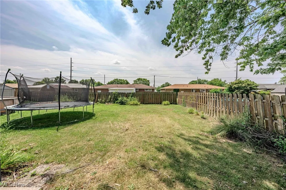 Fenced backyard with a trampoline