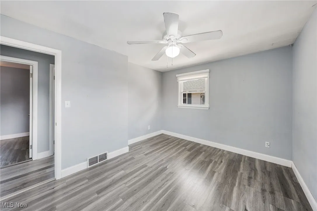 Empty room with wood finished floors and ceiling fan
