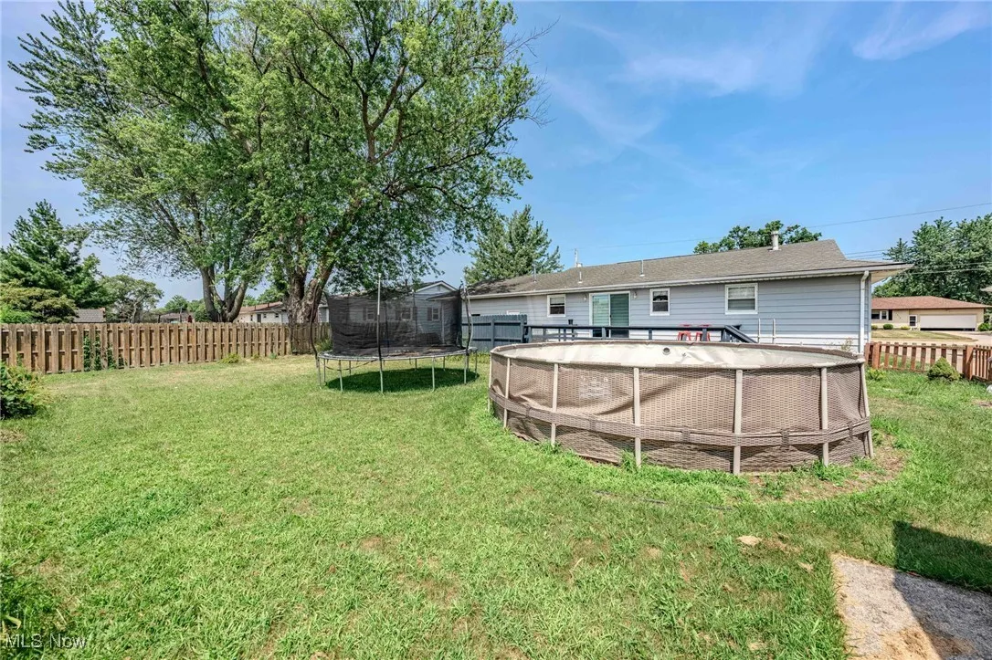 Fenced backyard with a trampoline