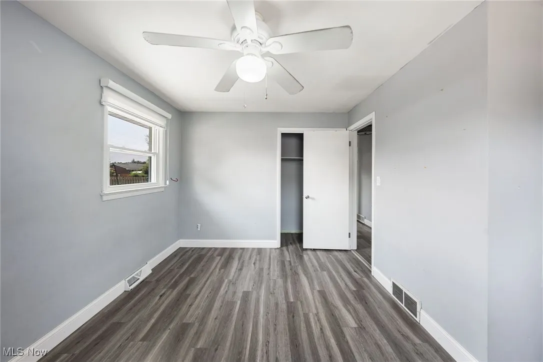 Unfurnished bedroom featuring wood finished floors, a closet, and a ceiling fan