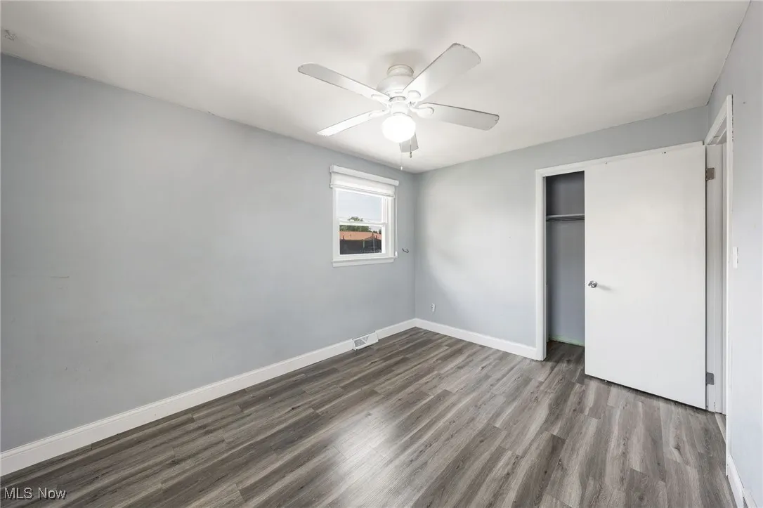Unfurnished bedroom featuring wood finished floors, a closet, and ceiling fan