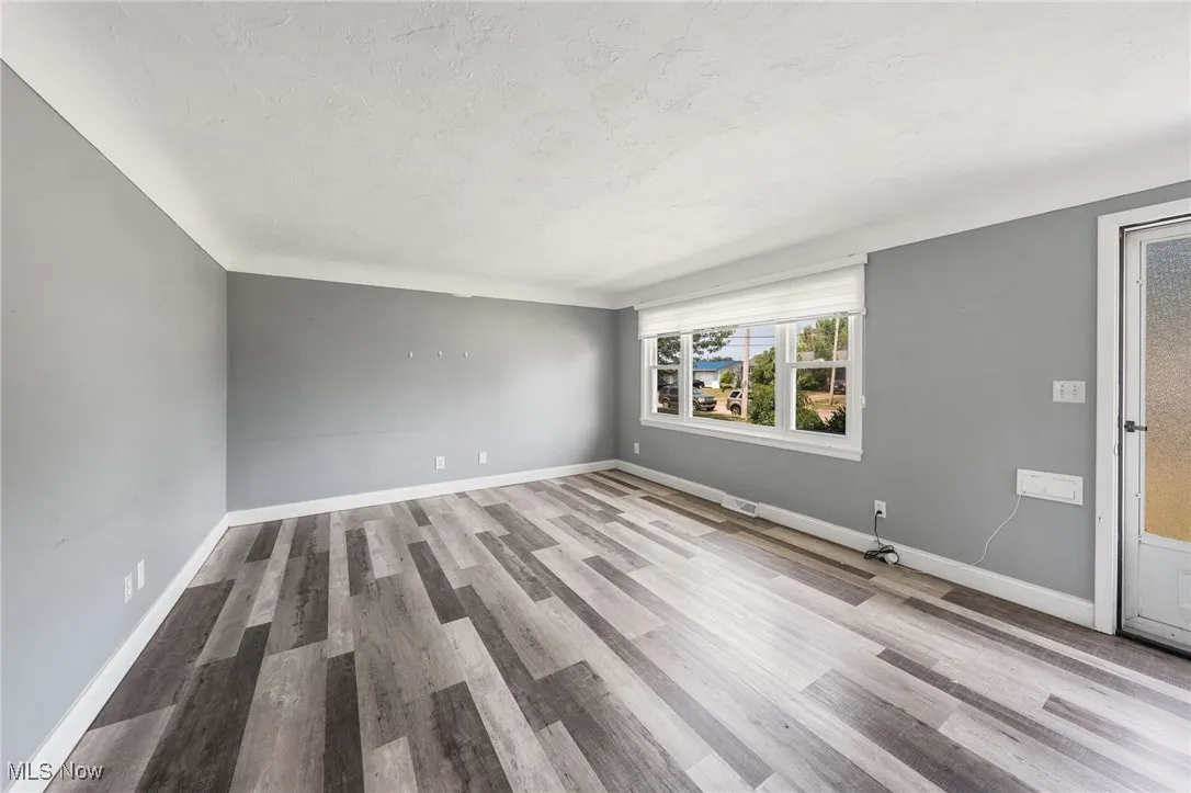 Unfurnished room featuring wood finished floors and a textured ceiling