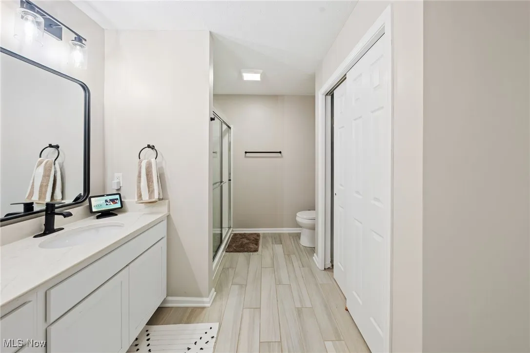 Bathroom featuring vanity, a shower stall, and wood finished floors