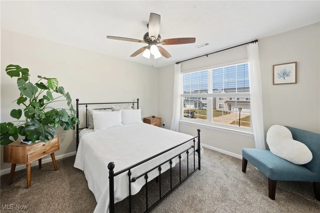Carpeted bedroom featuring baseboards and ceiling fan