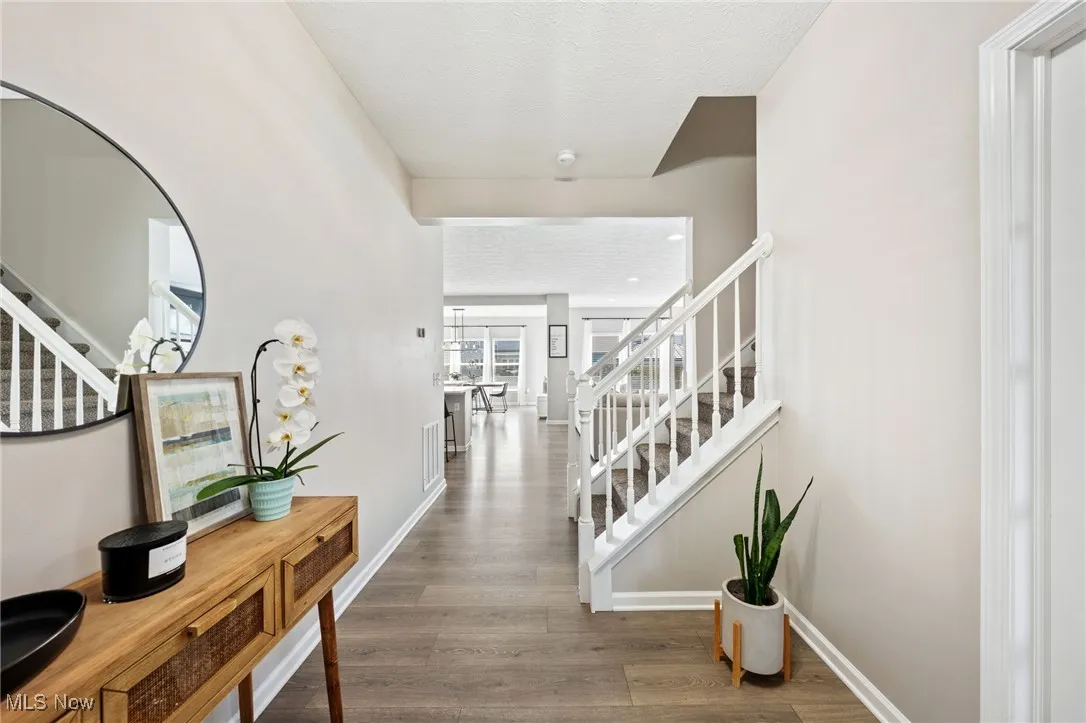 Corridor featuring stairs and wood finished floors