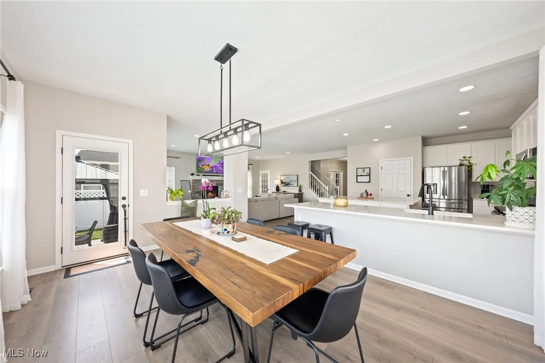 Dining space with recessed lighting, light wood-type flooring, and stairs