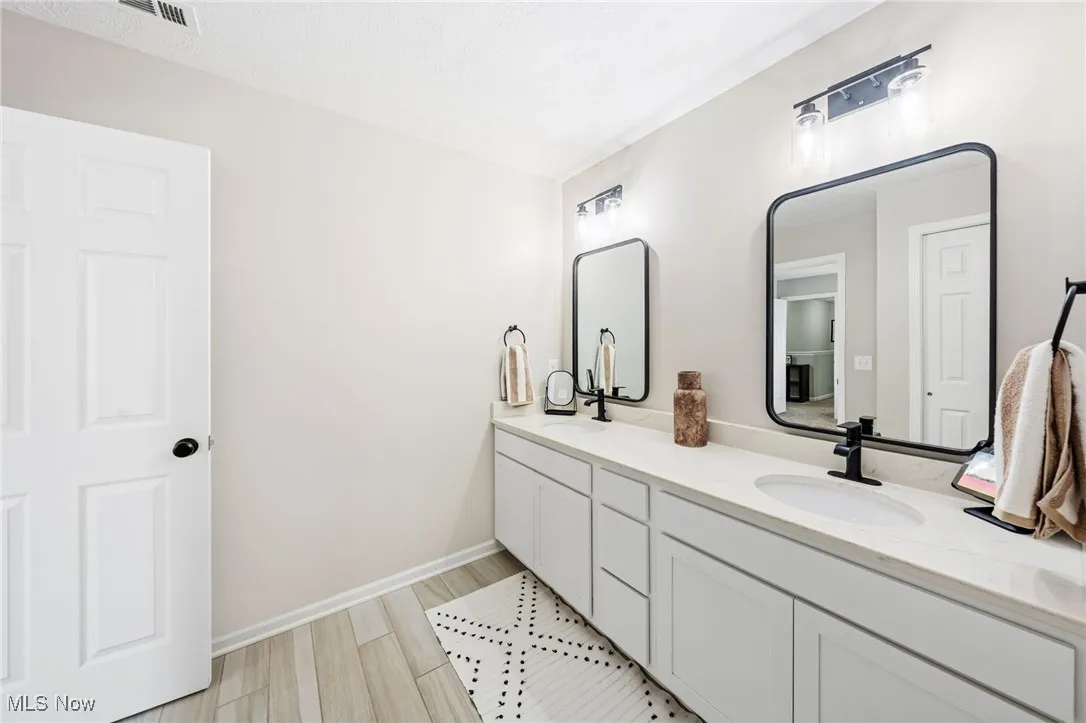 Bathroom featuring double vanity and baseboards